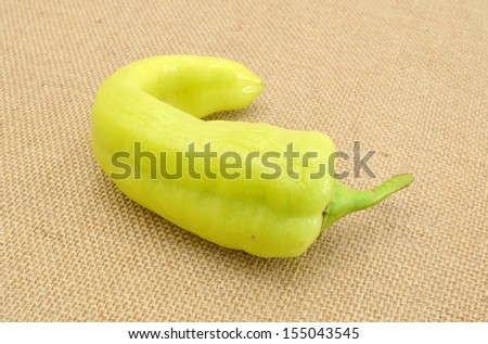 Single Banana Pepper isolated against on burlap background