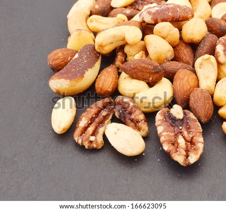 Mix nuts, dry fruits and chocolate on black  background