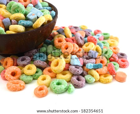 Delicious and nutritious fruit cereal loops flavorful in wooden bowl on white background, healthy and funny addition to kids breakfast