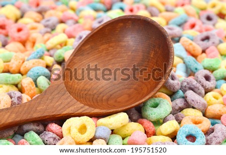 Delicious and nutritious fruit cereal loops flavorful and wooden spoon on bamboo mat, healthy and funny addition to kids breakfast