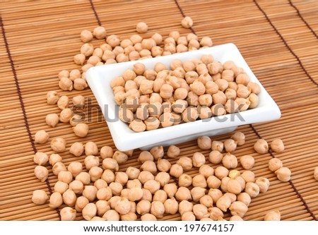 A small handful of chick-pea in plate  Beans isolated on bamboo mat. Close-up.
