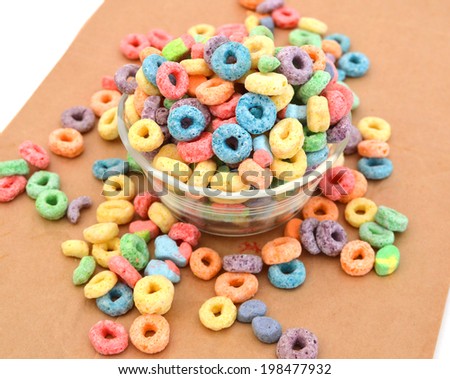 Delicious and nutritious fruit cereal loops flavorful in glass bowl on brown paper, healthy and funny addition to kids breakfast