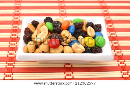 trail mix in white bowl on bamboo mat