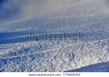 A lone skier on a ski hill.