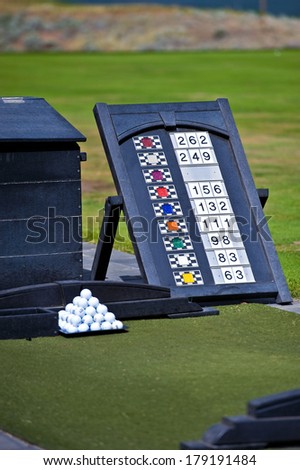 Golf balls and flag distances ready for a golfer on a driving range