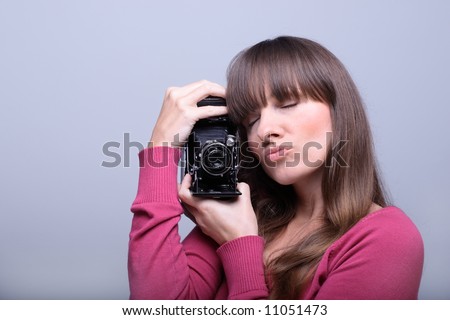 Young beautiful  woman holding a vintage photo camera