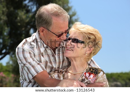 romantic senior couple relaxing outdoors looking in each other\'s eyes