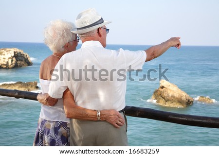 together into the future - senior couple looking into the distance holding each other