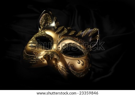 ornate carnival mask over black silk background