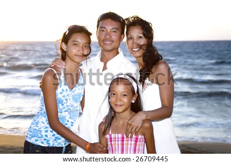 family lifestyle portrait of a mum and dad with their two daughters at the seaside