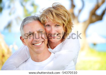 Close-up portrait of a mature couple smiling and embracing. Focus on the woman.