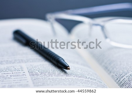 Glasses and a pen on a book