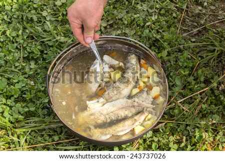 Fish soup in a kettle outdoors. pike fish soup