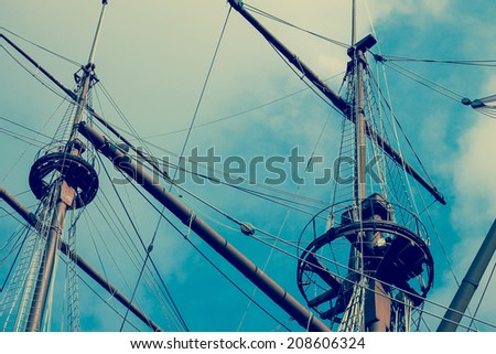 pirates ship masts on sky background creative blue vintage colors