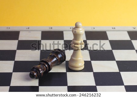 Chess queen wooden figurines fighting photo with wooden chess pawns and chessboard.