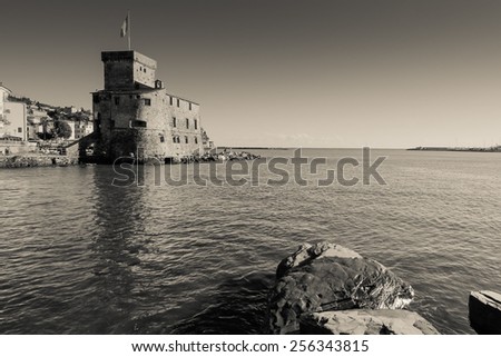 Ancient castle by the sea in Rapallo, Italy, black and white photography.