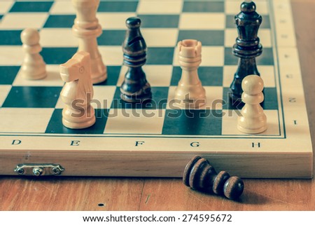 Chess set and chess pawn on wooden table, game and strategy concept, vintage photography.