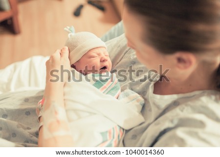 Mother in hospital holding her new born baby boy. Birth and new life.