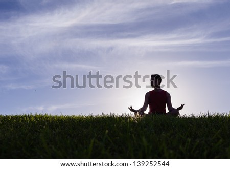 Silhouette of young man meditating