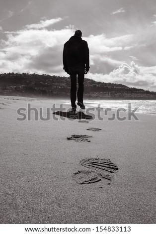 Lonely Man Walking On A Beach (Black And White)