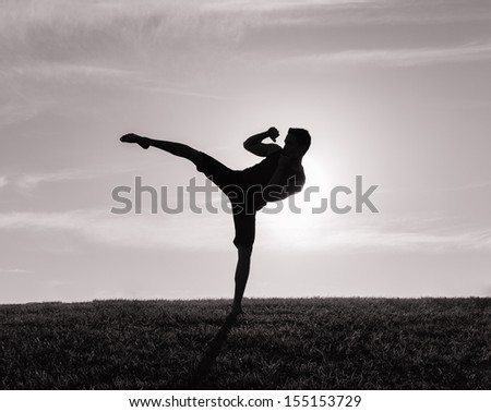 Silhouette of man exercising thai boxing
