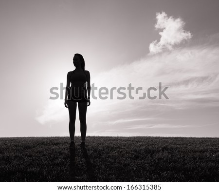 Lonely woman standing alone on the hill (black and white)