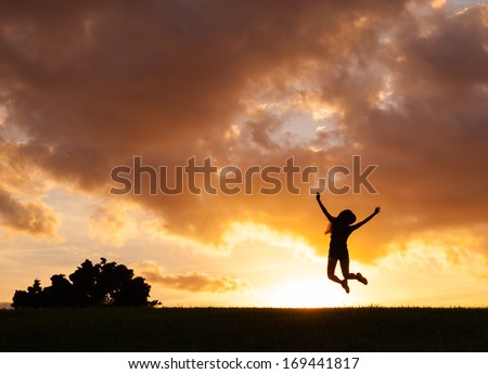 Happy woman jumping against sunset. Freedom concept. Enjoyment.