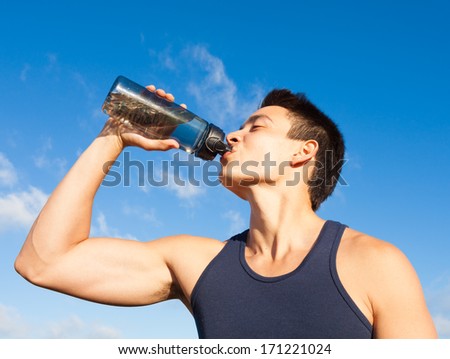 Handsome young man drinking water