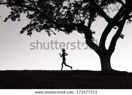 Silhouette of woman running outdoor at sunset