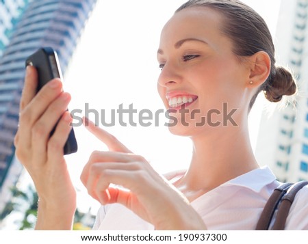 Business woman using mobile smart phone - Happy smiling business woman using mobile smart phone outdoors.