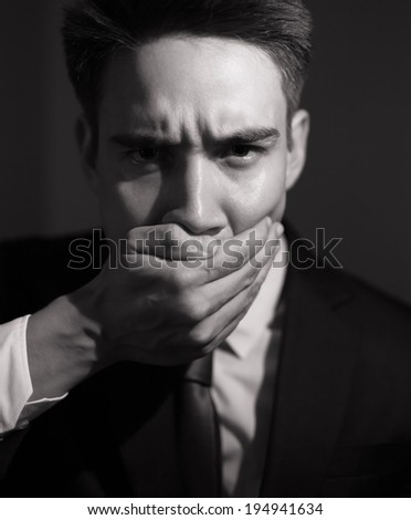 Speak no evil concept - Businessman covering his mouth.