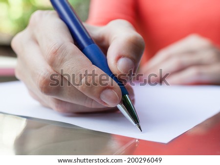 Hands of young woman signing paper.