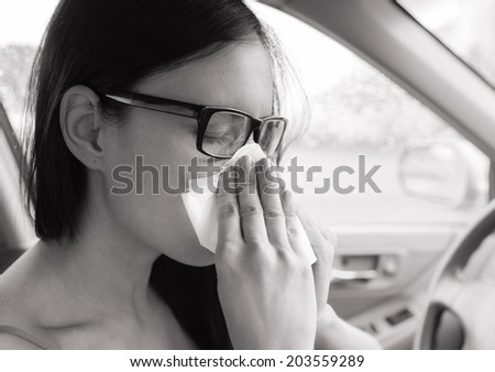 Flu cold or allergy symptom. Sick woman girl sneezing in tissue in the car. Health care.