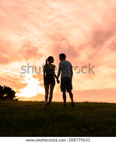 Happy couple holding hands in the sunset.