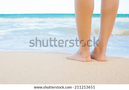 Close up detail of female feet and golden sand in Hawaii.