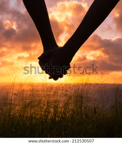 Couple holding hands in the sunset