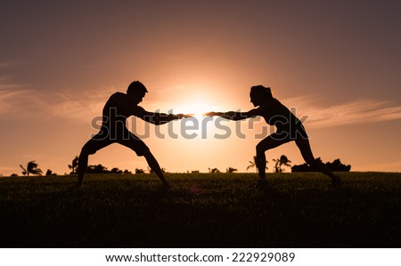 Man and woman playing tug of war in the park