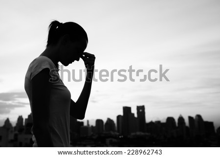 Sad and depressed woman deep in thought with city background