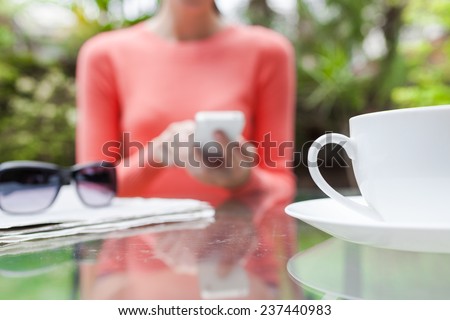 Woman using smart phone in a cafe setting