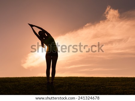 Silhouette of woman practicing yoga in the park Silhouette of woman practicing yoga in the park