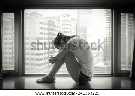 Sad woman sitting alone in an empty room