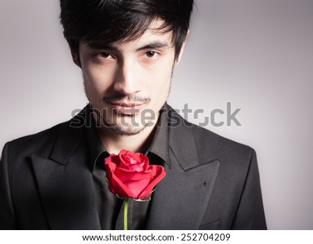 Handsome young man with single rose