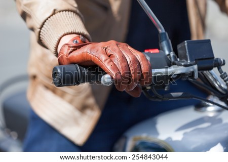Human hand in the gloves holds a motorcycle throttle control