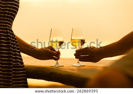 Romantic couple enjoying wine by the sea