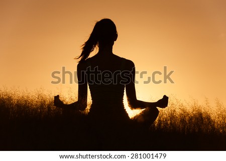Woman meditating in a peaceful setting.