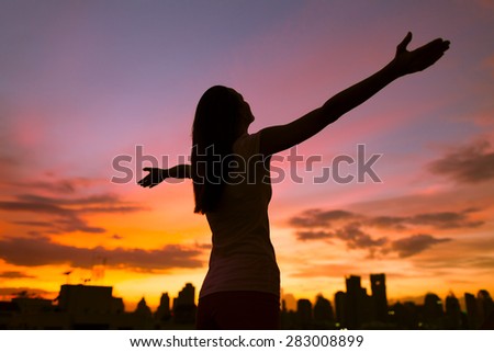 Woman with arms open feeling free in the city.