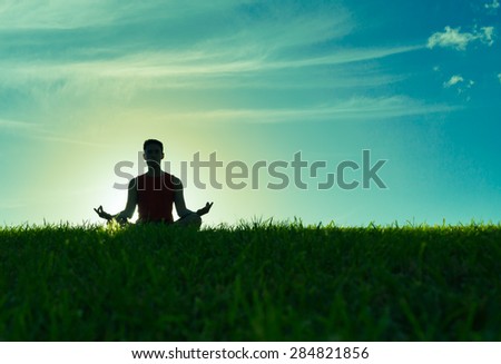 Male relaxing outdoors in the lotus position.