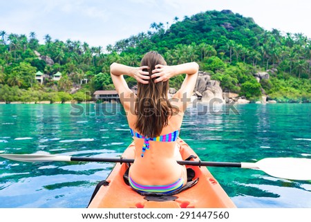 Woman kayaking on a tropical island getaway. (location Thailand)