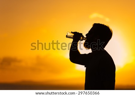 Fit male drinking a bottle of water.