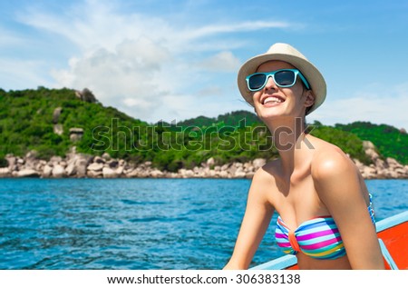 Young female traveler on a boat traveling to a exotic island.